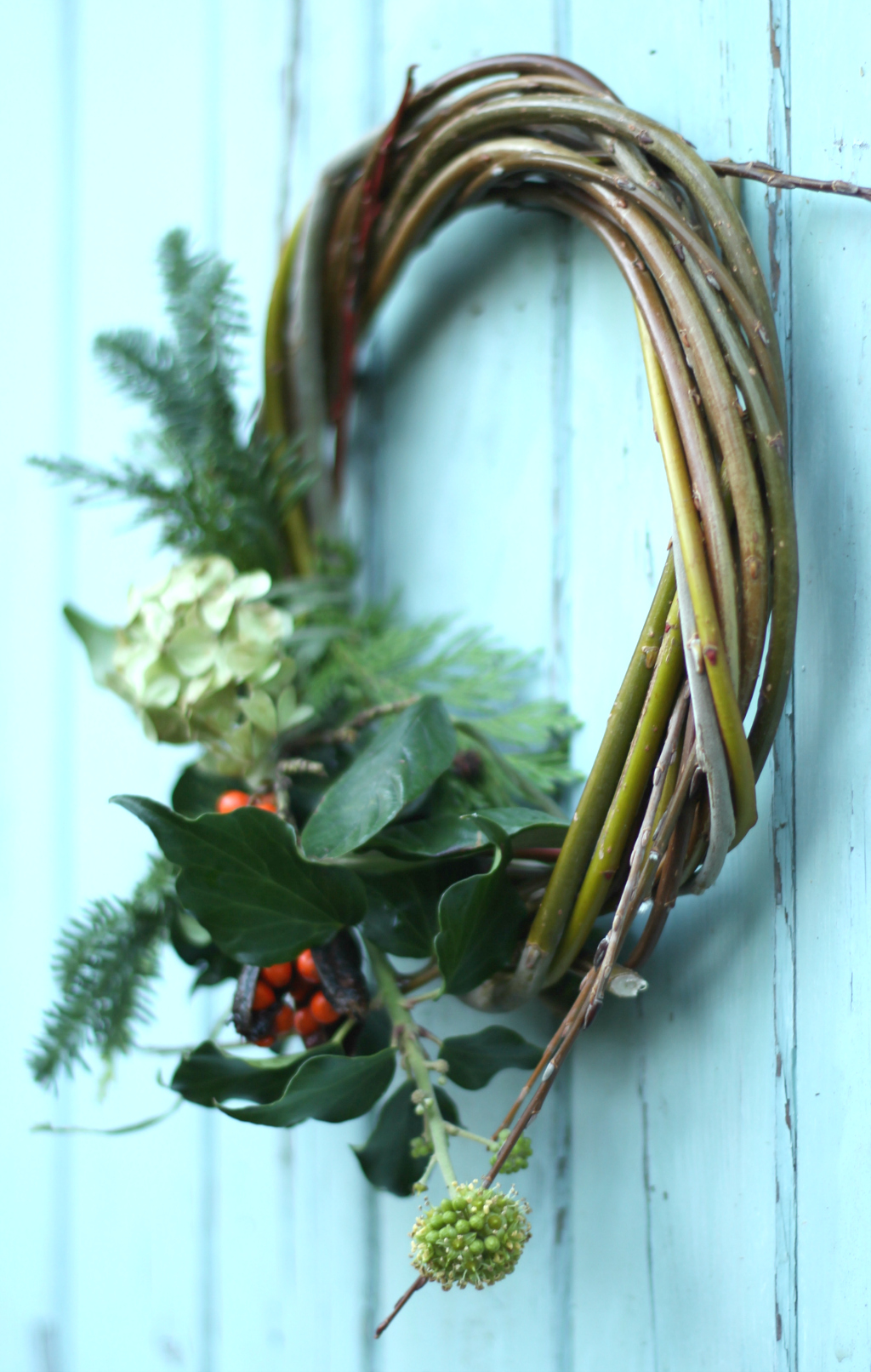 A willow wreath with a small evergreen garland. Tuckshop Flowers